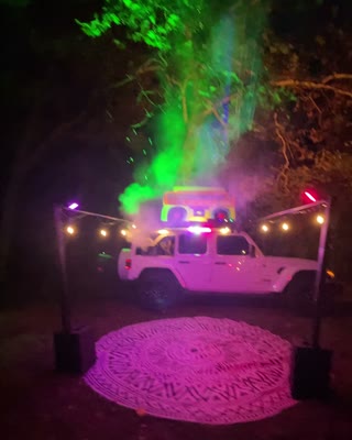 Green and magenta lights above the nighttime BoomBoxCar setup